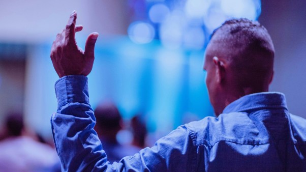 A pastor holding his hands up in church.