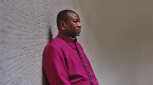 Headshot of Yassir Eric leaning against a textured wall