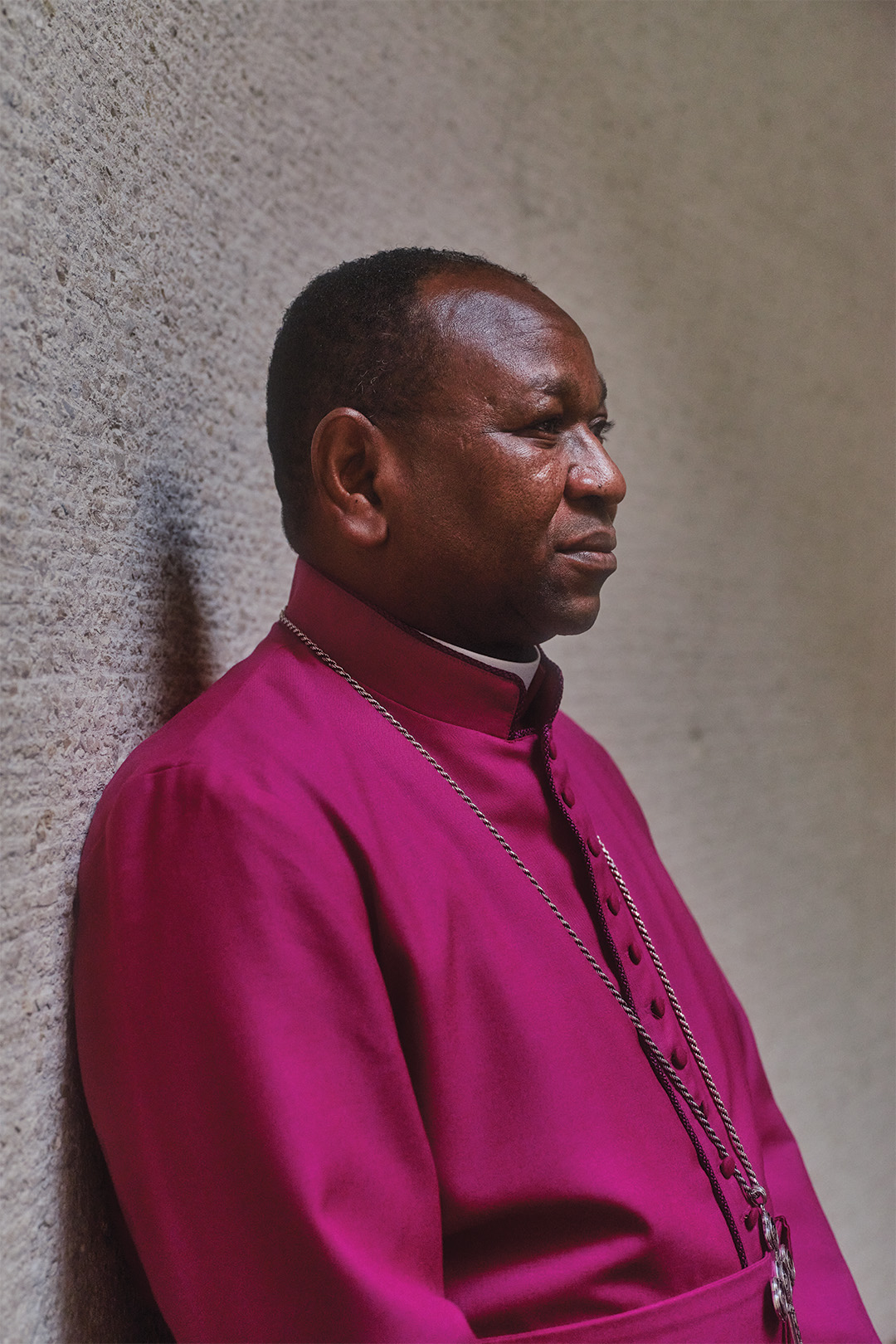 Headshot of Yassir Eric leaning against a textured wall