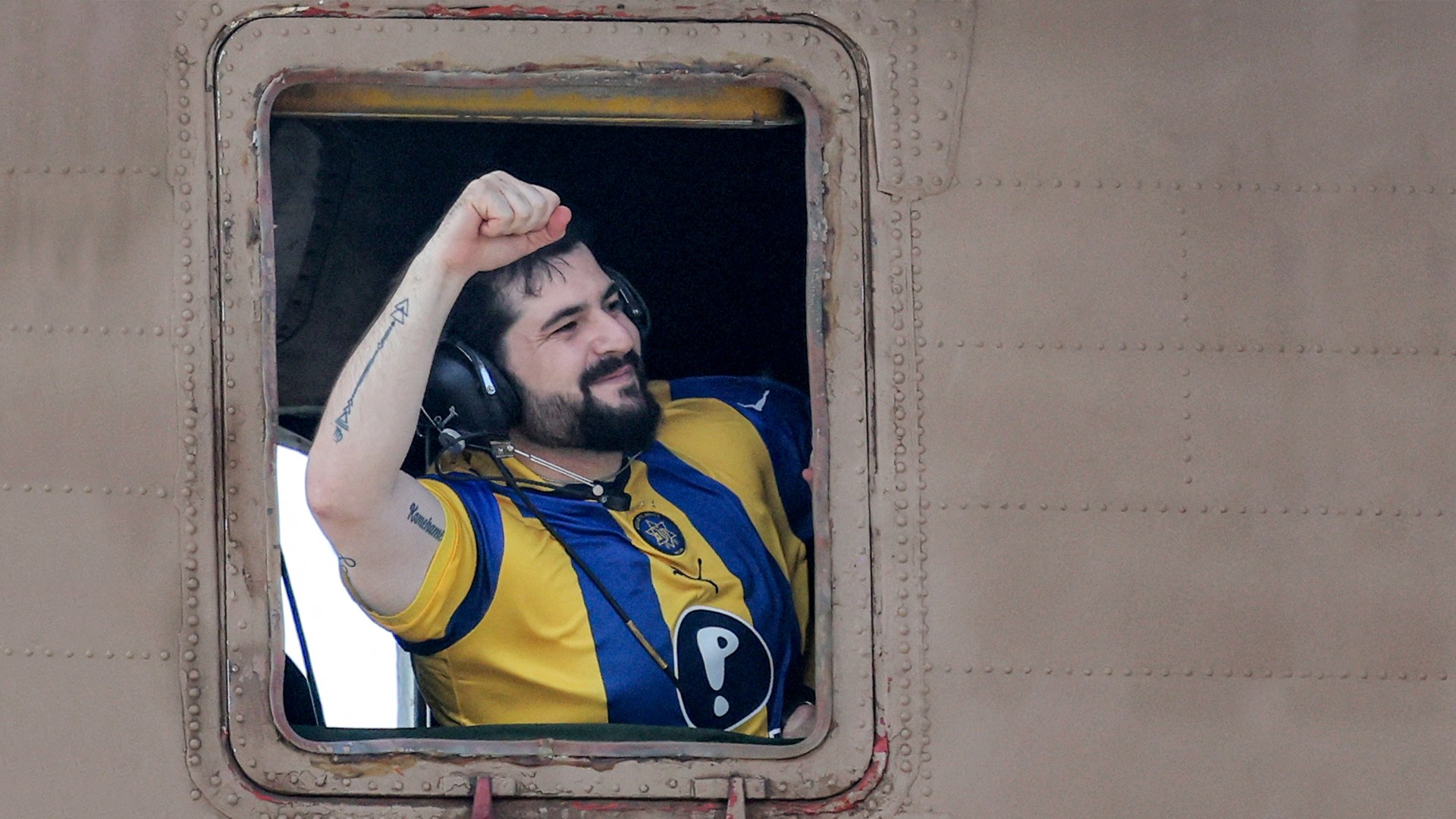 Ziv Berman, one of the released Israeli hostages formerly held captive in Gaza since 2023, gestures from the window of an Israeli helicopter.