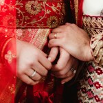 An Indian bride and groom holding hands.