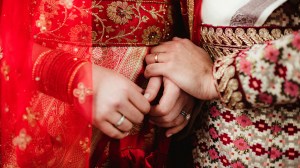 An Indian bride and groom holding hands.