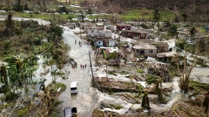 Flooded roads and damaged houses visible from a drone.
