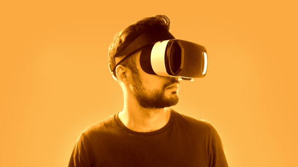 A man looking into virtual reality goggles.