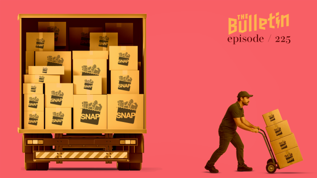 A man with a cart with boxes on it that say "SNAP," walking away from a truck loaded with boxes that say "SNAP."