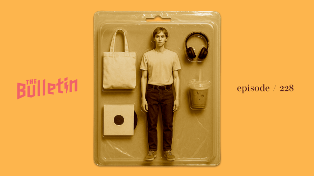 A male doll in a plastic package, along with a tote bag, a record, headphones, and an iced matcha latte.