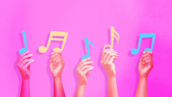 Hands holding up music notes.