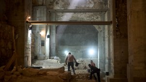 Workers from the Israel Antiquities Authority excavate a section of a city wall from the Hasmonean period in the Old City of Jerusalem.