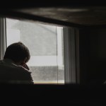 A man sitting by a window.