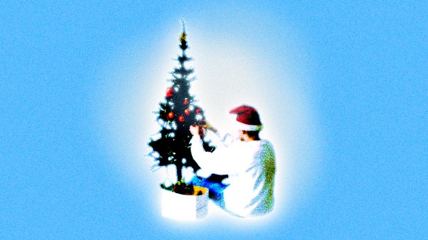 A teenage boy decorating a Christmas tree.