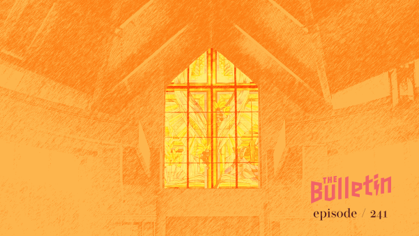 A stained class window from the inside of a church, monochromatic orange.