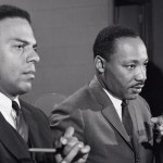 Dr. Martin Luther King Jr. at a press conference accompanied by his aide Reverend Andrew Young.