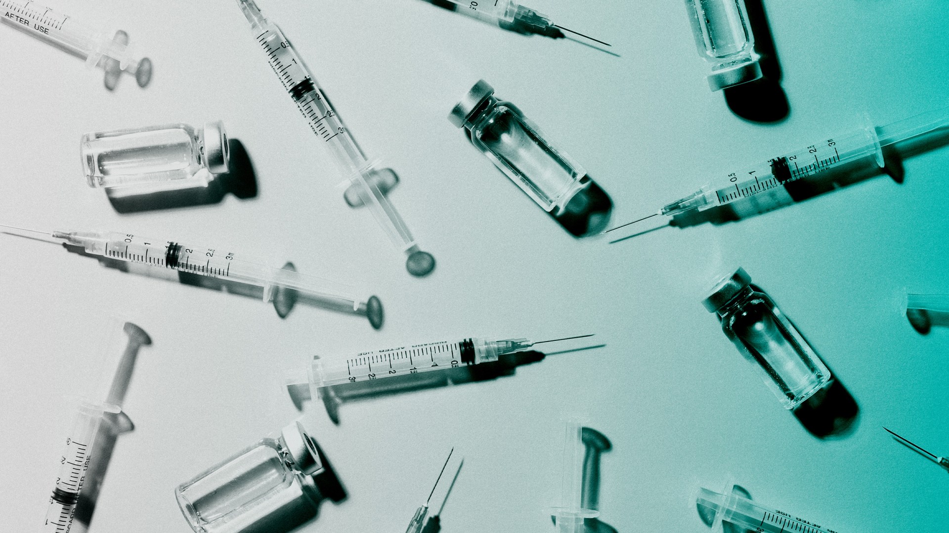 Several medical syringes and vaccine vials.