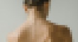 A pixelated image of a woman's neck and shoulders.