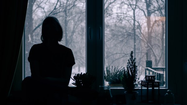 A person looking out of a snowy window.