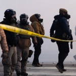 Federal agents stand in tear gas and face protesters on Nicollet Avenue in south Minneapolis on January 24, 2026.