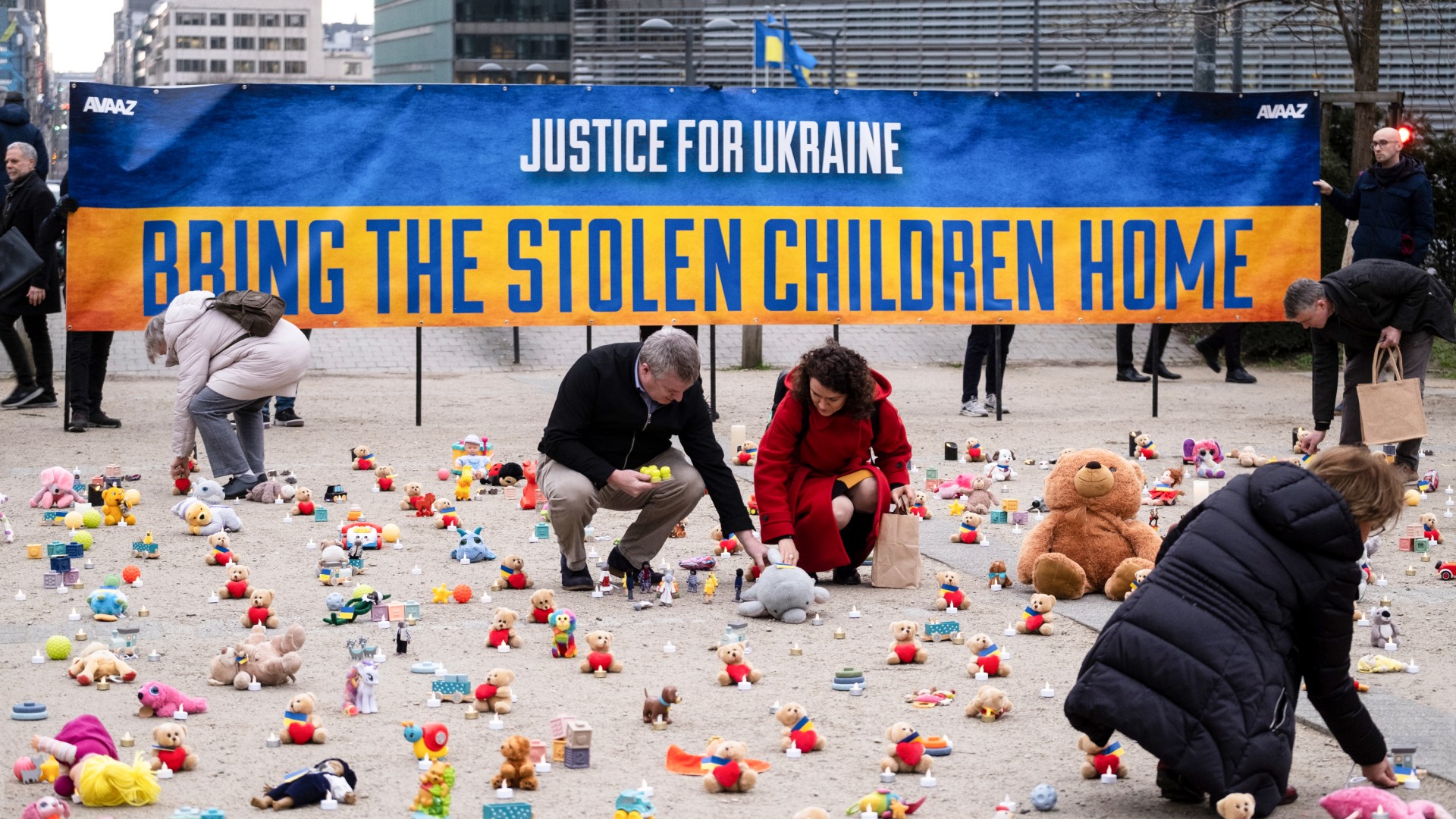 People from the nonprofit organization, AVAAZ, light candles in Belgium beside teddy bears for Ukrainian children who have been kidnapped.