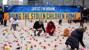 People from the nonprofit organization, AVAAZ, light candles in Belgium beside teddy bears for Ukrainian children who have been kidnapped.