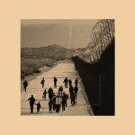 A photo of families and children walking along a US border.