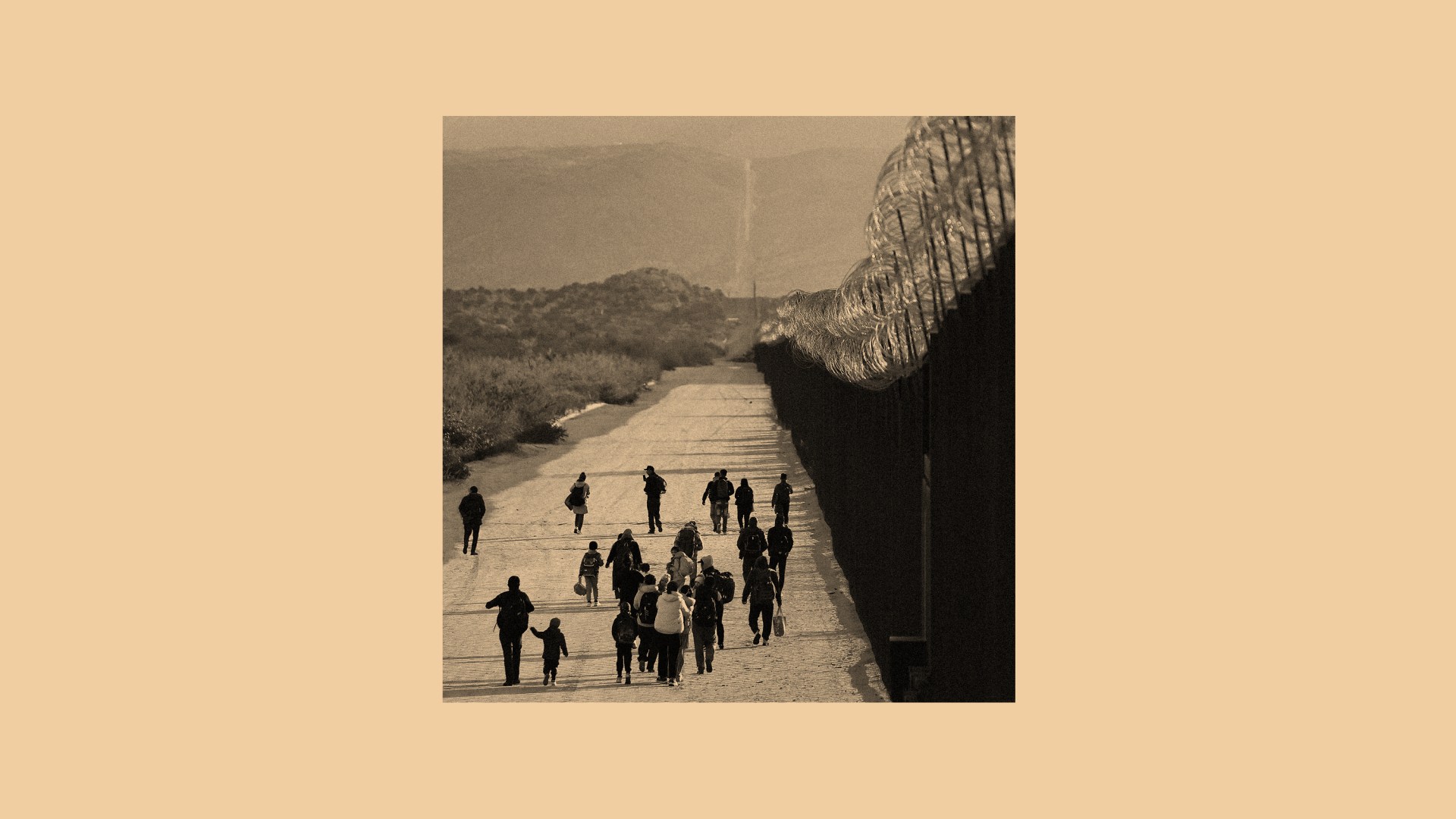 A photo of families and children walking along a US border.