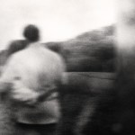 A blurry black and white photo of a couple hugging.