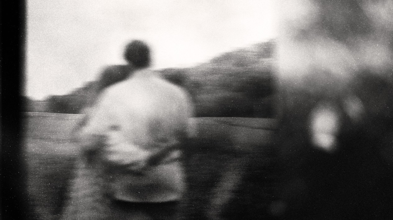 A blurry black and white photo of a couple hugging.