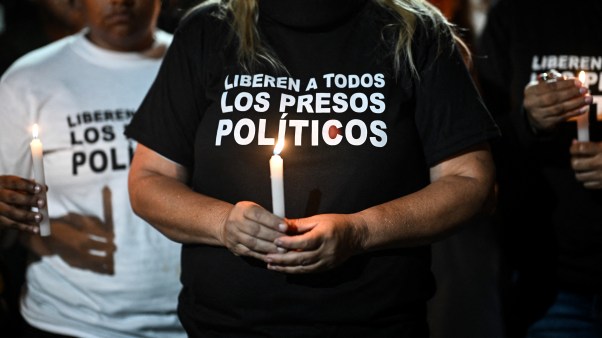 A woman holds a candle during a vigil to demand the freedom of Venezuelan political prisoners.
