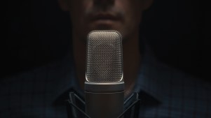 A blurred photo of a man behind a microphone