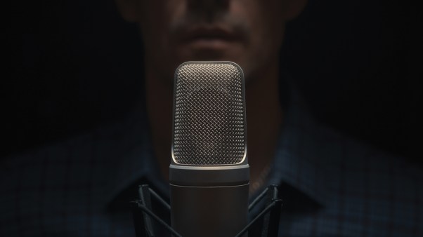 A blurred photo of a man behind a microphone