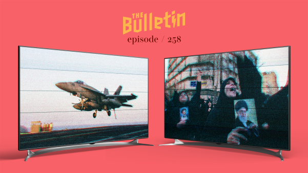 Two TV screens, one with an image of a fighter plane taking off, and the other with protesters holding a picture of the Ayatollah Ali Khamenei.