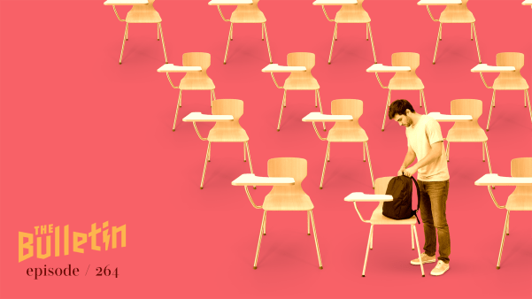 A man standing alone in a classroom.