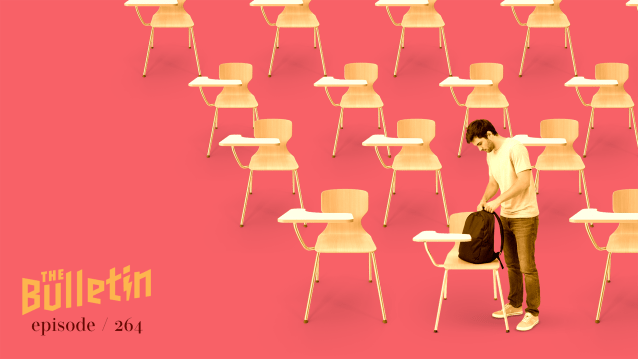 A man standing alone in a classroom.