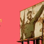 A billboard with an old propaganda poster of Fidel Castro with a machine gun.