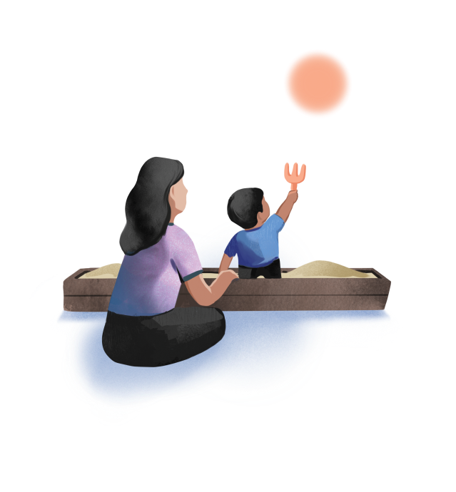 Mother sitting beside a sandbox while a child reaches up with a toy toward the sun.
