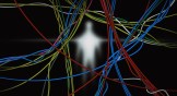 Blurred glowing human figure behind a tangle of colorful cables against a dark background.