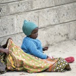 Two Kenyan children sitting on the streets of Nairobi.