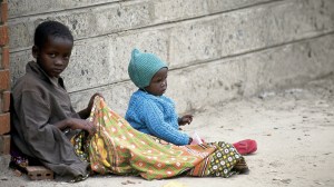 Two Kenyan children sitting on the streets of Nairobi.