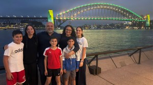 The Elachi family at the Sydney Harbour Bridge on December 10, 2025, the day of the social media ban. The sign on the bridge behind them reads, “Let Them Be Kids.”