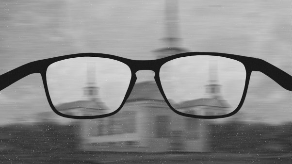 A pair of glasses with blurry churches in the lenses.