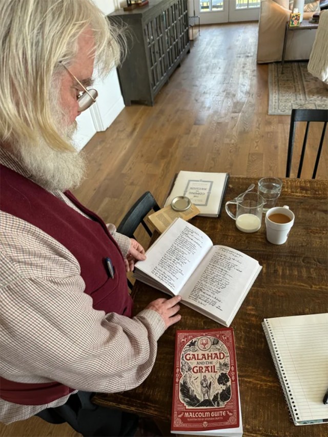Malcolm Guite holding his hand-written poem.