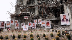 Portraits of victims are displayed in the rubble of the residential building where they were reportedly killed in a US-Israeli airstrike in Tehran on April 13, 2026.