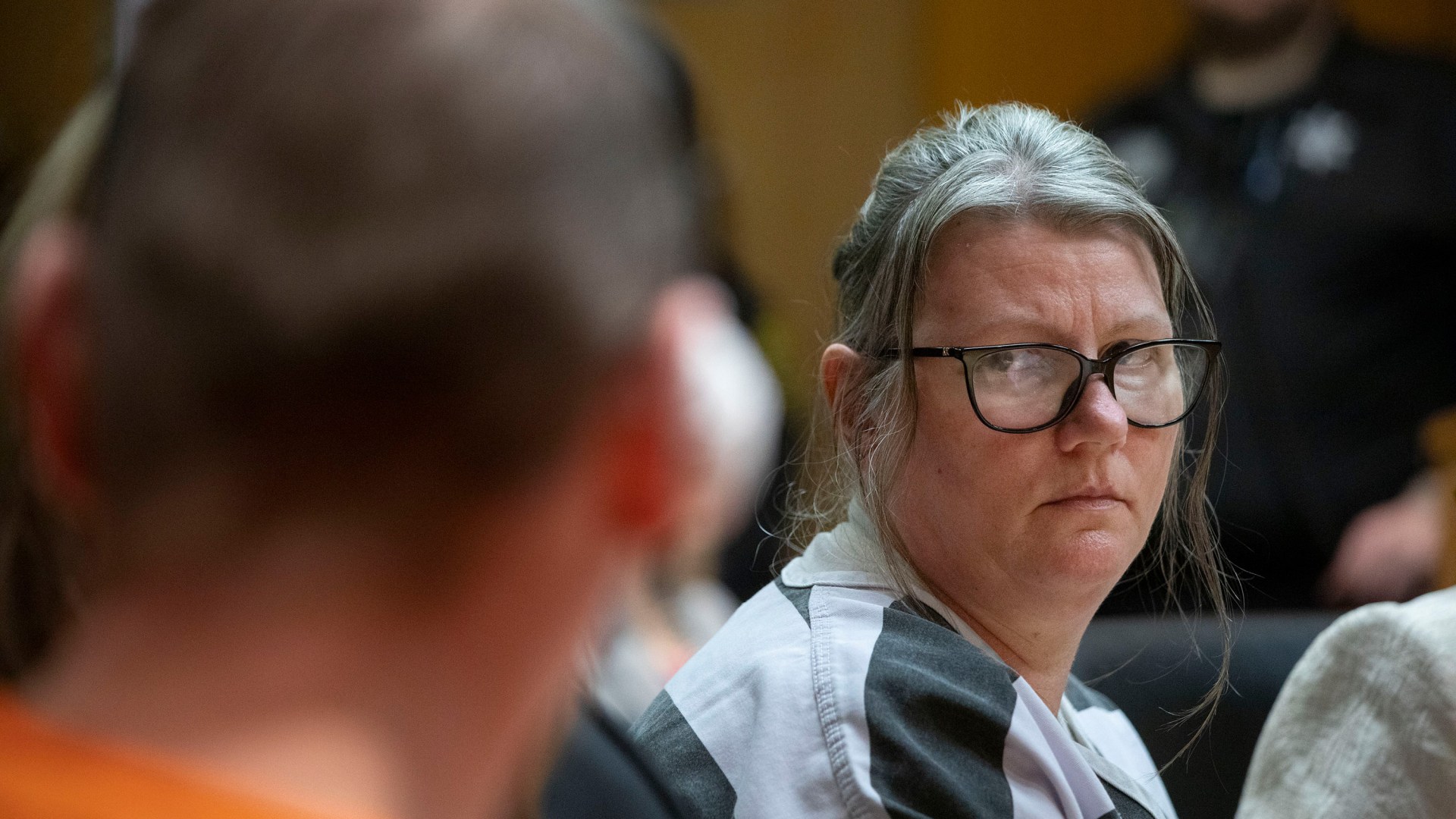 Jennifer Crumbley looks at her husband James Crumbley during their sentencing on April 9, 2024 in Pontiac, Michigan. They are the first parents in U.S. history to be criminally tried and convicted for a mass school shooting that was committed by their child.