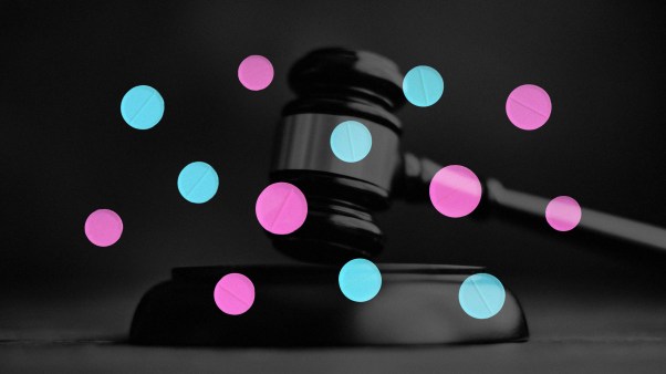 A gavel and pink and blue pills.