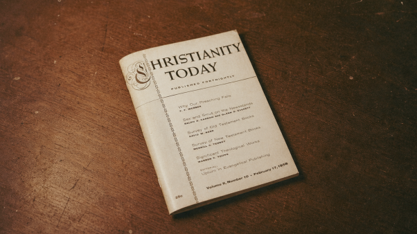 A vintage Christianity Today magazine from February 17, 1958 rests on a worn wooden table.