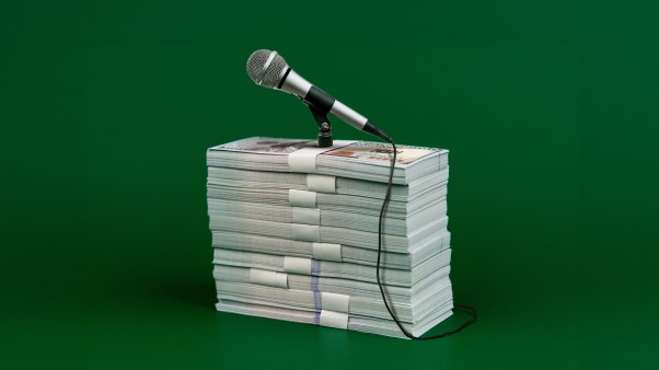 A stack of money used as a podium for a microphone.