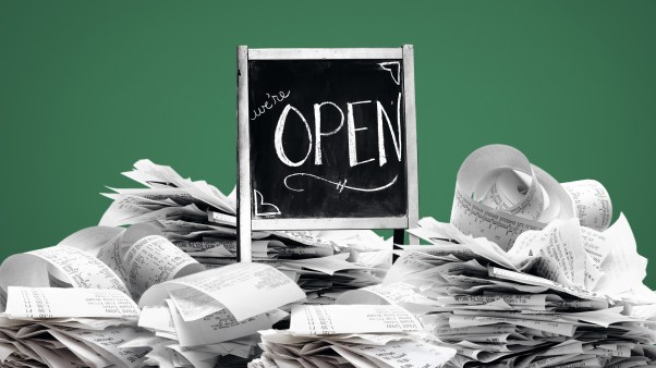 An "open" sign buried in a pile of receipts.