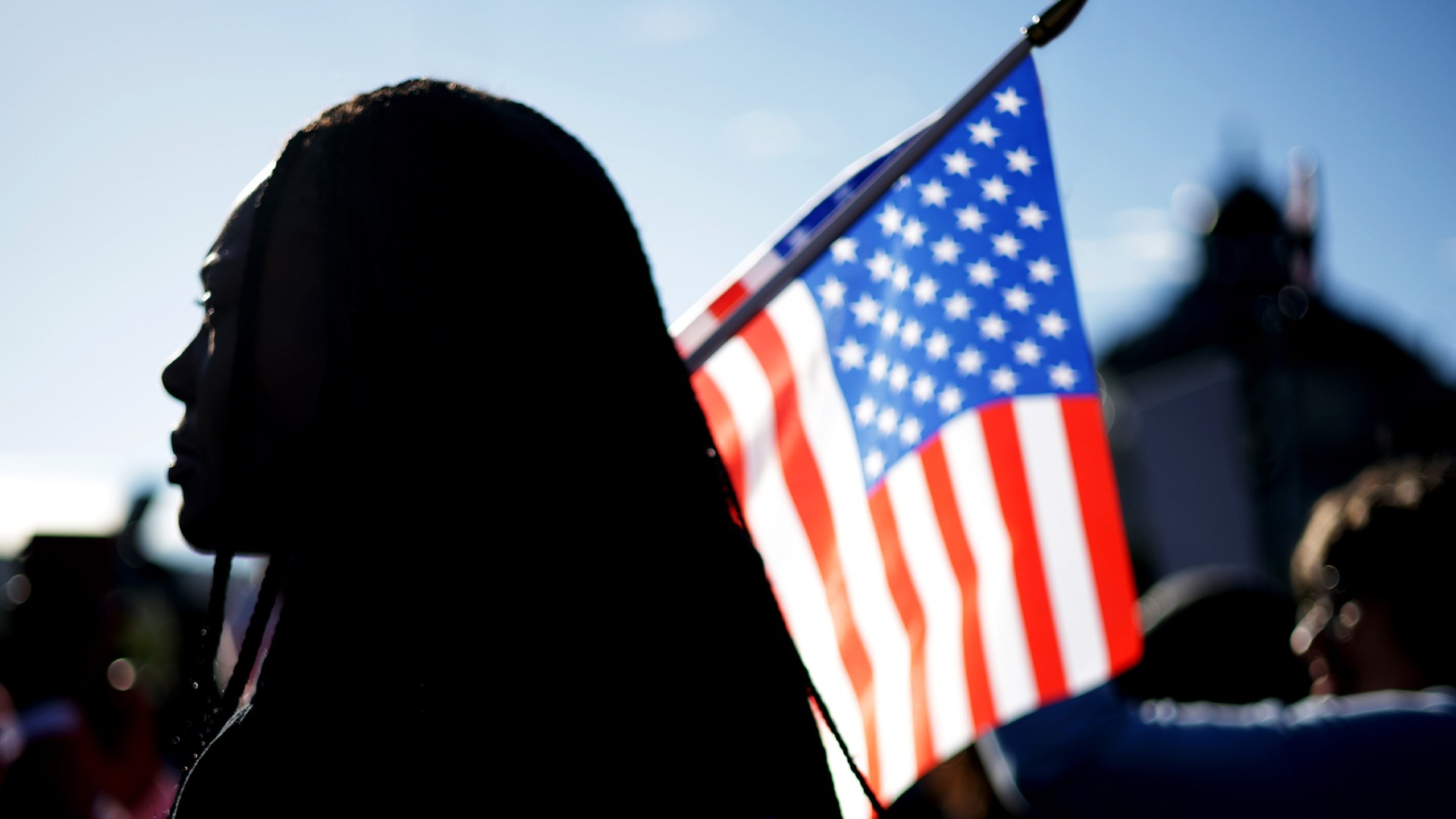 An activist holds a U.S. flag during a rally in front of the U.S. Supreme Court as it prepares to hear oral arguments in Louisiana v. Callais on October 15, 2025.